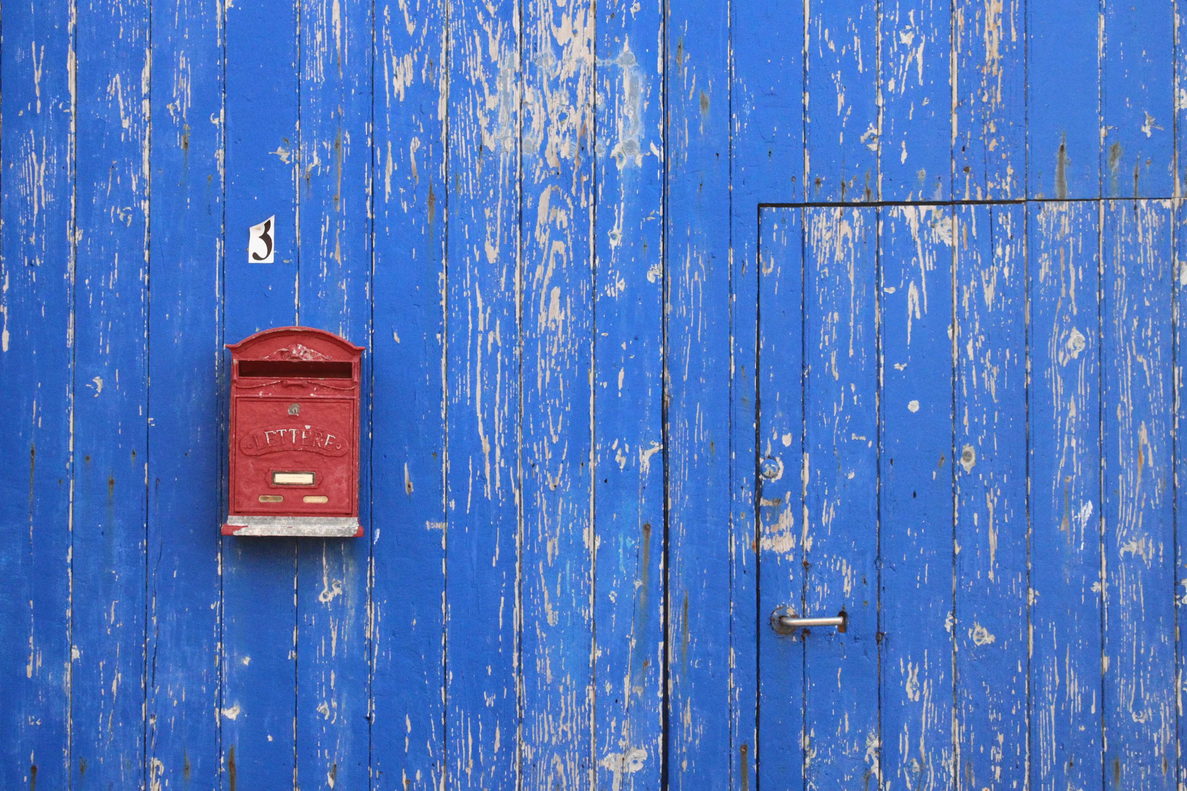 red mailbox on blue wall